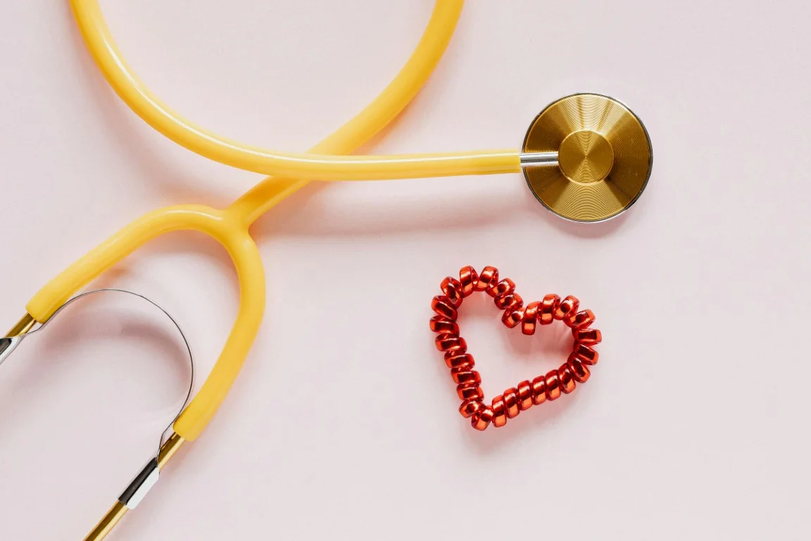A stethoscope beside a red heart-shaped object