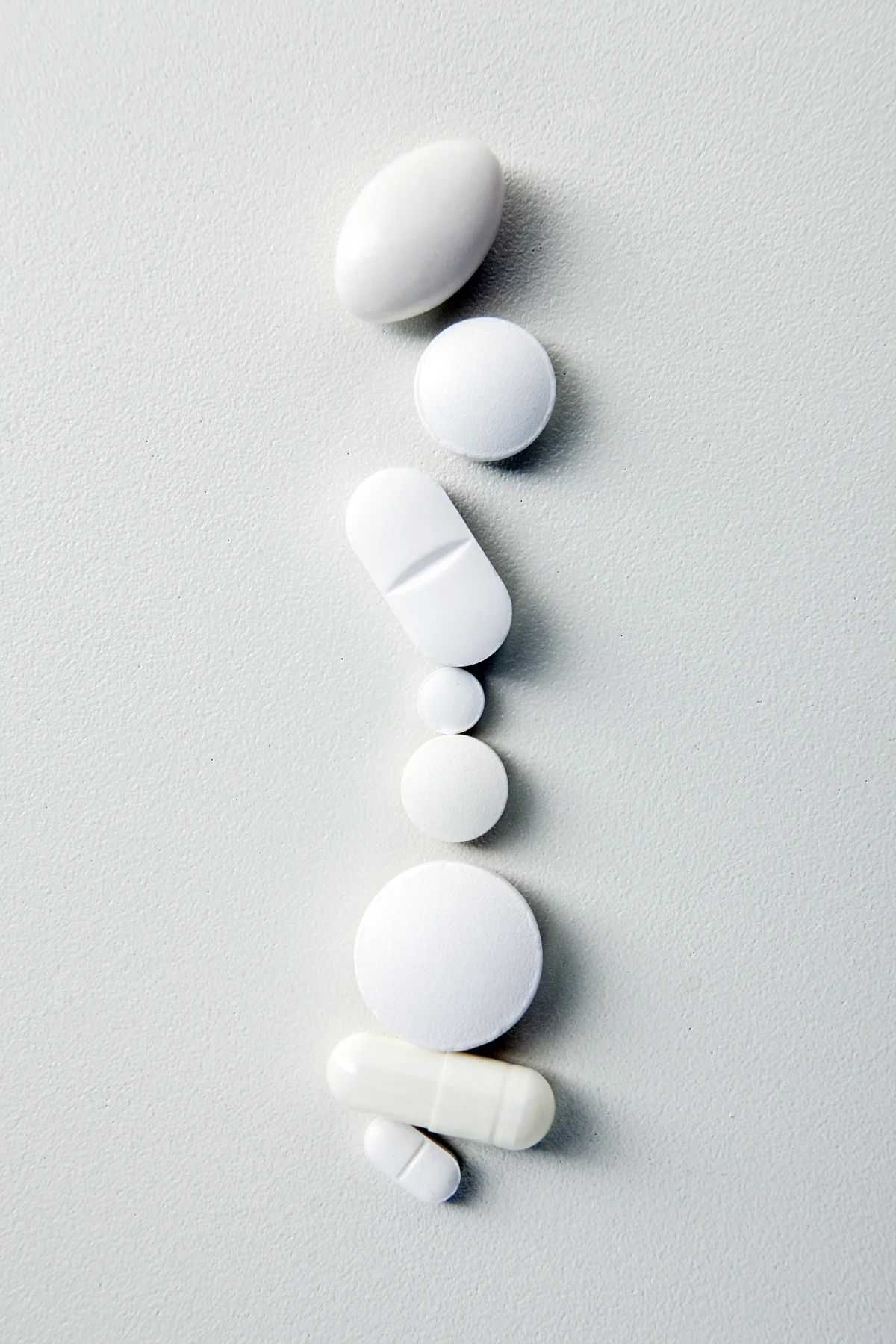 White medicine tablets arranged on a pale clinical surface